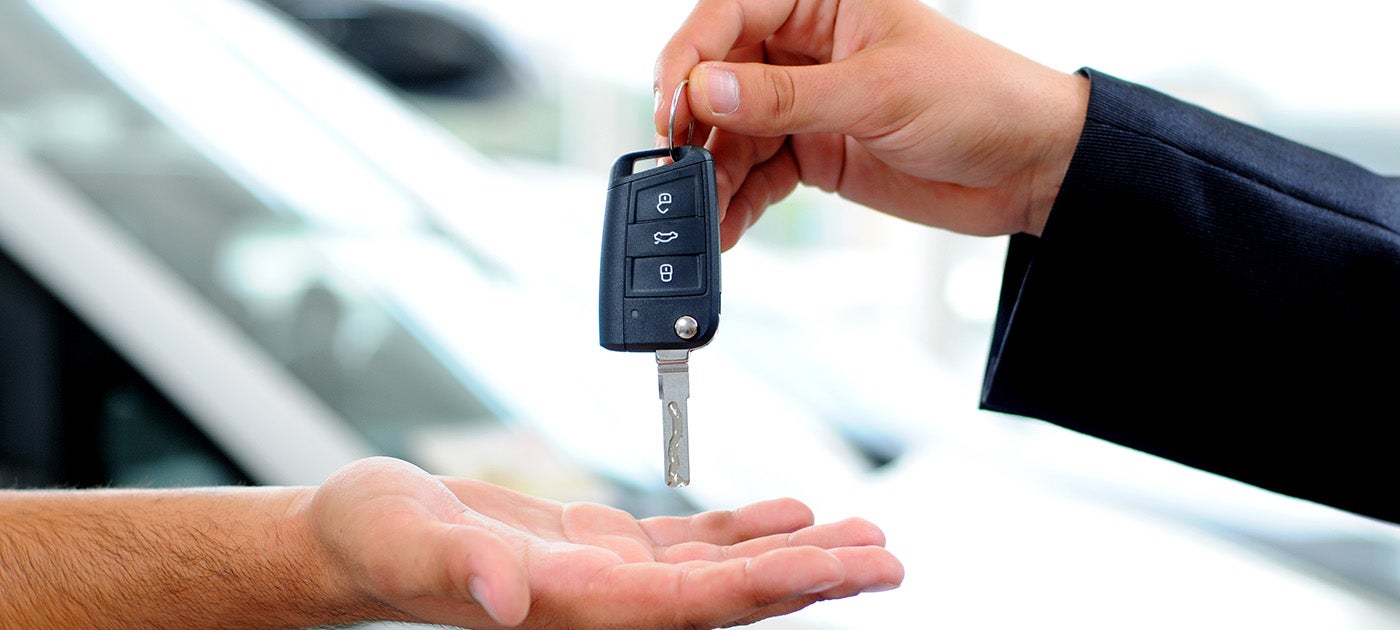 Customer receiving vehicle keys after completing the car buying process