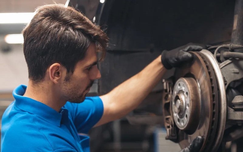 person inspecting car brakes